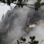 Breathtaking view of the Paro Taktsang Monastery nestled in Bhutan's misty mountains.