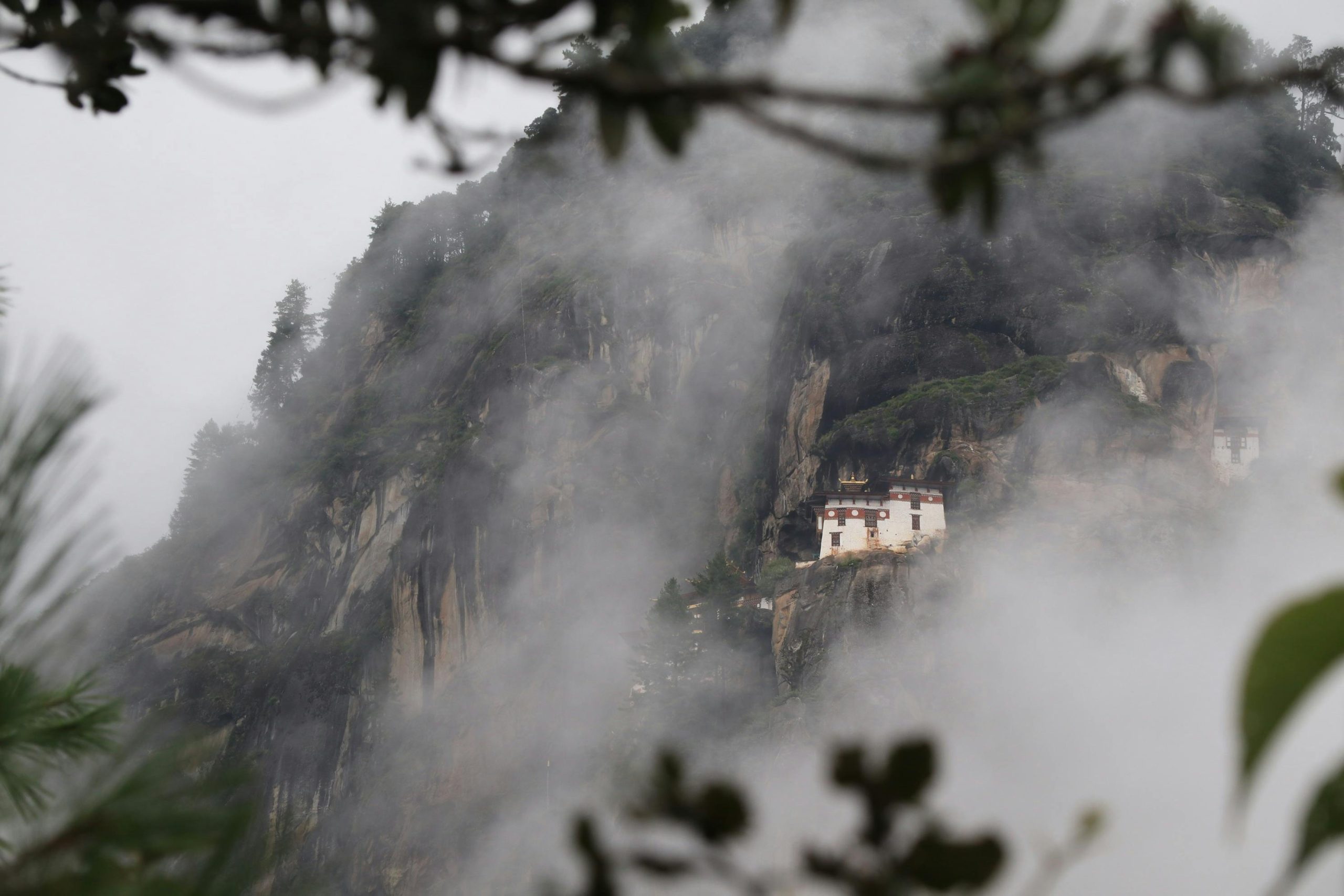 Breathtaking view of the Paro Taktsang Monastery nestled in Bhutan's misty mountains.